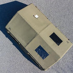 Aerial view of large khaki camping tent with two rectangular windows on gravel surface