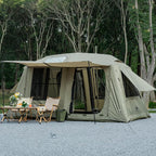 Spacious camping tent with large windows and doors set up outdoors with chairs and a table